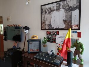 A view of his living room which shows his poster of George Fernandes figurines of wrestlers above th